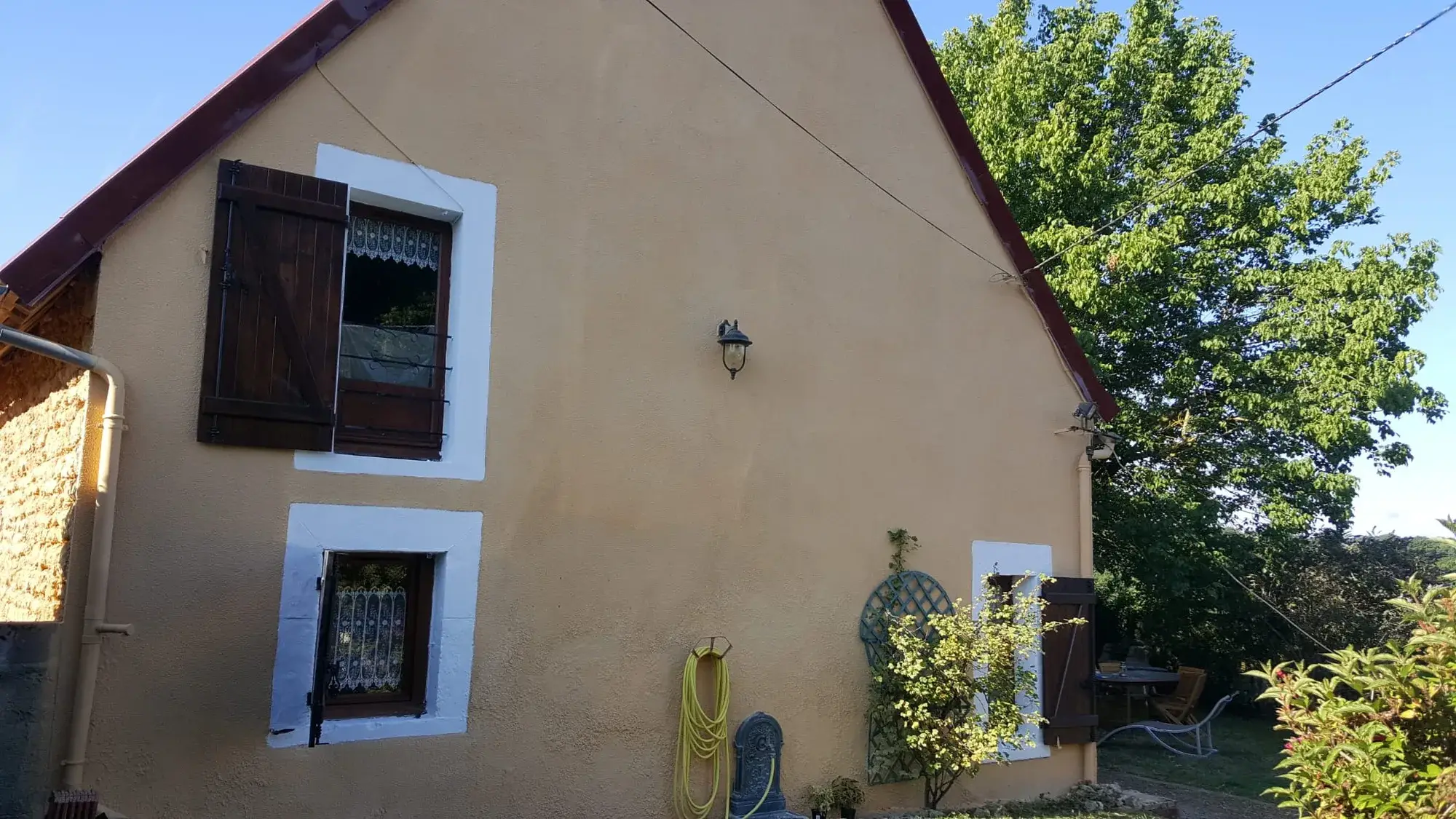 Pignon repeint en ocre avec rives métalliques neuves et encadrements de fenêtres repris