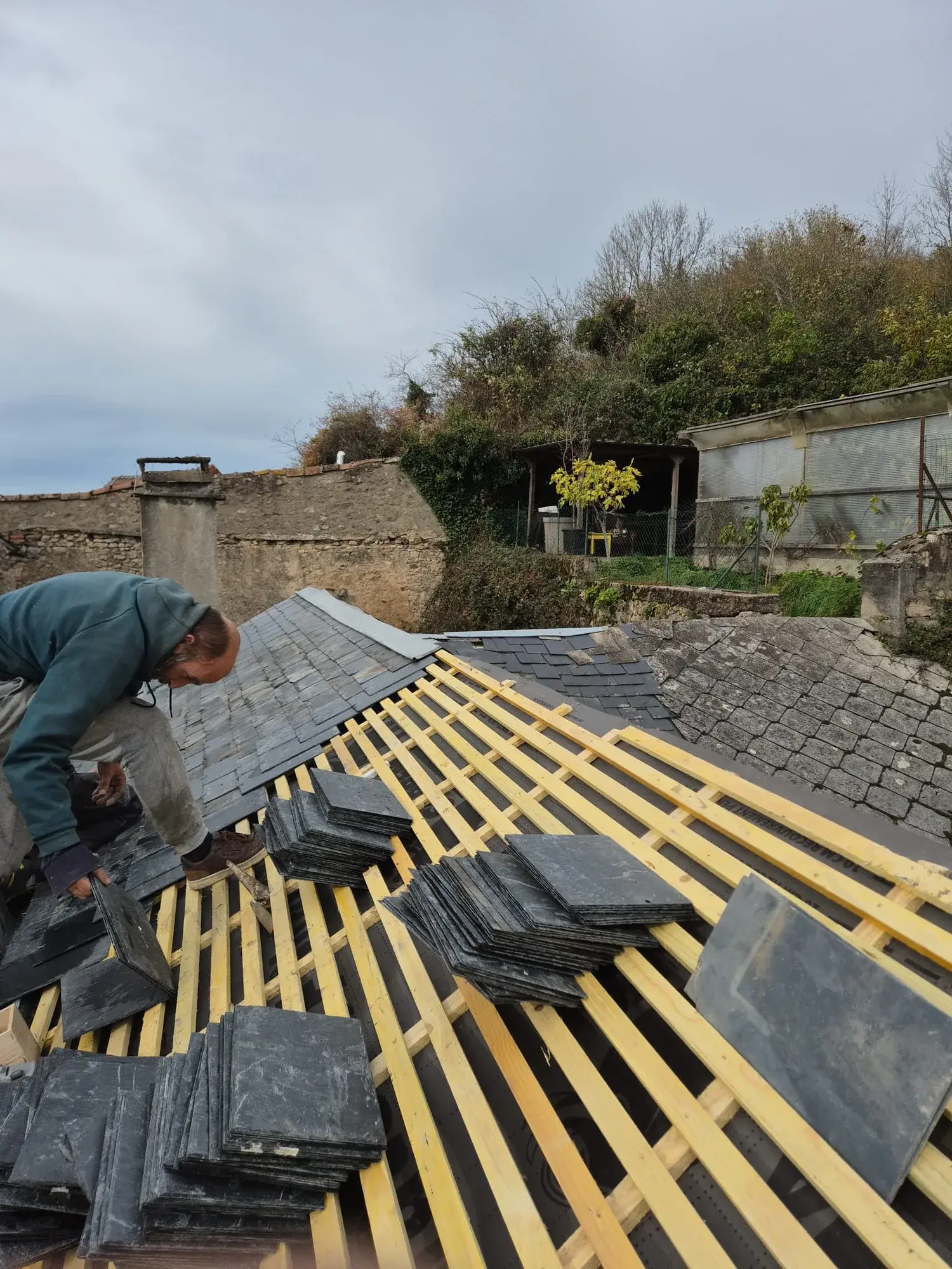 Couvreur de Renov' Habitat 58 posant des ardoises neuves sur écran de sous-toiture dans la Nièvre