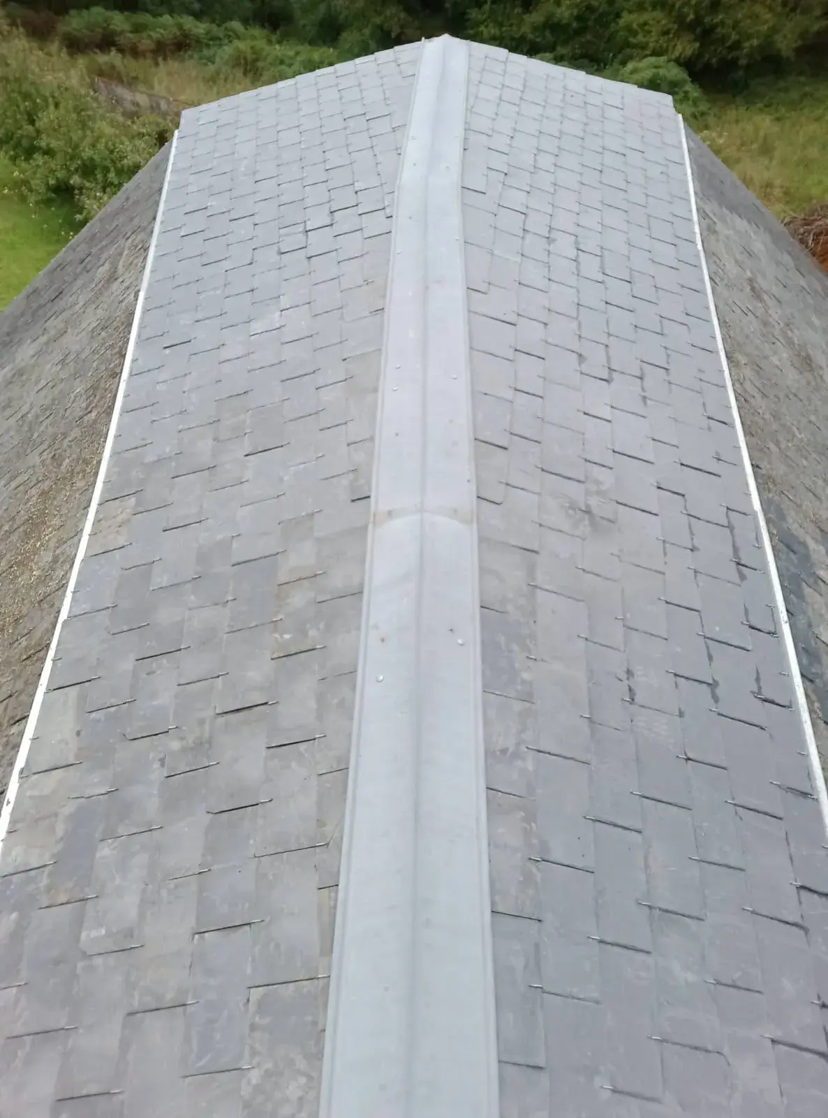 Toiture en ardoise neuve terminée, faîtage en zinc et crochets inox